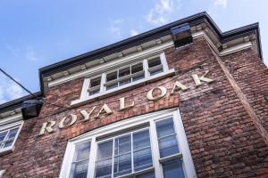 een bakstenen gebouw met een koninklijk eiken bord erop bij The Royal Oak Hotel, Welshpool, Mid Wales in Welshpool