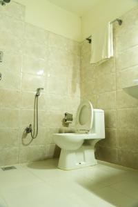 uma casa de banho com um WC e uma cabina de duche. em Hotel Maden Inn em Itahari