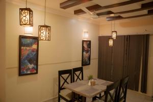 a dining room with a table and chairs and lights at Hotel Maden Inn in Itahari