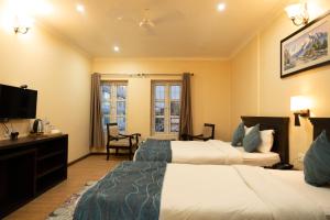 Hotel Maden Inn في Itahari: غرفة فندقية بسريرين وتلفزيون بشاشة مسطحة