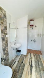 uma casa de banho com um lavatório e um chuveiro em The Meraki Beach Resort em Gokarna