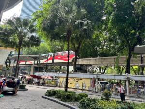 un train sur un pont sur une rue bordée de palmiers dans l'établissement Vortex Suites Klcc by Rit Villa, à Kuala Lumpur