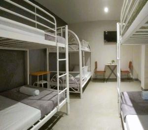 a room with two bunk beds and a table and chairs at HOST HOMESPACE in Tacloban