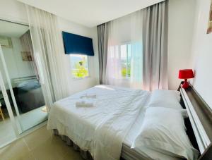 a bedroom with a white bed with a window at Phuket naka condon-52-45 免费高速上网免费停车 in Phuket