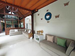 a living room with couches and butterflies on the wall at Villa Harmony - Residence in Seminyak