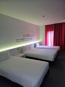 リスボンにあるホテル 3K エウロパのベッド2台と窓が備わるホテルルームです。
