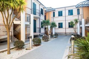une cour d'un immeuble avec des palmiers dans l'établissement S338 - Sirolo, delizioso trilocale con terrazzino, à Sirolo