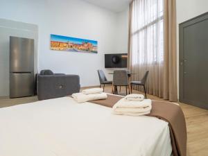 um quarto de hotel com uma cama com toalhas em Apartamentos La Fuensanta em Córdoba