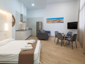 um quarto de hotel com uma cama, uma mesa e cadeiras em Apartamentos La Fuensanta em Córdoba