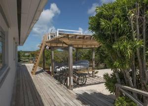 een fiets geparkeerd onder een terras op een huis bij Beachfront Bliss Private Estate with Cottages in Savannah Sound