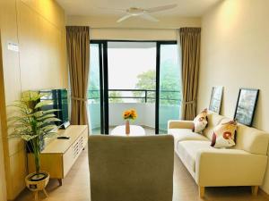 a living room with two couches and a large window at Mutiara Melaka Beach Resort by Minso in Tangga Batu