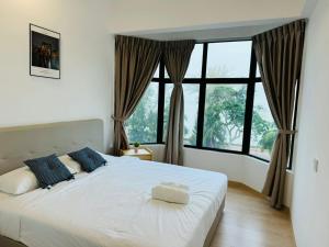a bedroom with a large white bed with windows at Mutiara Melaka Beach Resort by Minso in Tangga Batu