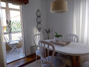a dining room with a white table and chairs at Solerma in Viveiro