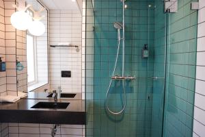 uma casa de banho com um chuveiro e um lavatório. em Comfort Hotel Norrköping em Norrköping