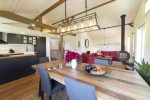 comedor y sala de estar con mesa de madera y sillas azules en Chalet Bergblick en Wildhaus