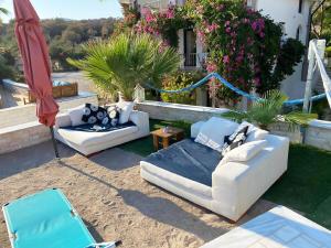 un patio con due divani e un ombrellone di Ferienhaus in Ermioni mit Grill, gemeinschaftlichem Pool und Terrasse a Thermisía
