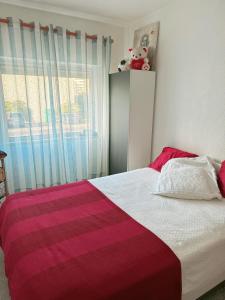 um quarto com uma cama com um cobertor vermelho e branco em Apartamento com boa luz e localização em Lisboa. em Lisboa