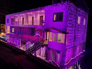 a building with purple lights on the side of it at Jamunas B&B in Shimla