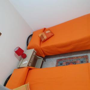 een uitzicht op twee bedden met oranje lakens bij villino scianuli in Torre Squillace