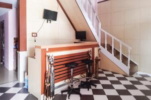 明古魯的住宿－RedDoorz at Pantai Panjang Bengkulu 2，一间位于 ⁇ 格地板上的房间,配有一张桌子和两张凳子