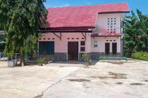明古魯的住宿－RedDoorz at Pantai Panjang Bengkulu 2，一间红色屋顶的粉红色小房子