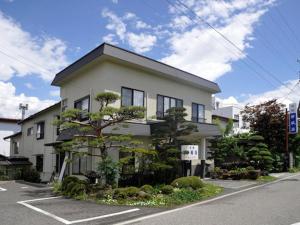 Ryokan Seifuso - Vacation STAY 85475v في ماتسوموتو: مبنى ابيض امامه شجرة