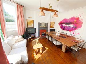 een woonkamer met een tafel en een witte bank bij The Table House Close to Town & Beach Free parking in Bournemouth