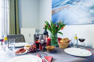 a table with plates of food and wine glasses at Birkenstraße 6 Haus II Whg5 in Zingst