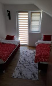 twee bedden in een kamer met een raam en een tapijt bij Sarajevo Holiday Apartment in Sarajevo