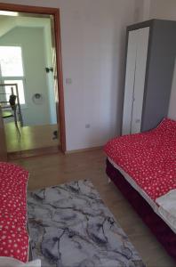 een slaapkamer met een rood bed en een spiegel bij Sarajevo Holiday Apartment in Sarajevo
