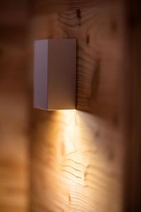 lampa z białym pudełkiem na drewnianej ścianie w obiekcie Maso Agritur Santa Lucia w mieście Dro