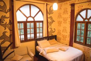 a bedroom with a bed and two windows at MF Holiday Bungalow in Bandarawela
