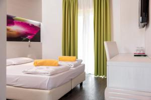 a bedroom with two beds and green curtains at Maso Agritur Santa Lucia in Dro