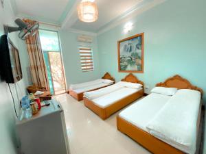 una camera con 2 letti e una TV a schermo piatto di Như Ý Hotel Lào Cai - by Bay Luxury a Pho Mới