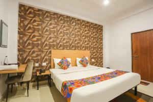 1 dormitorio con cama, escritorio, mesa y cama sidx sidx en FabHotel Pranjul Inn, en Allahābād