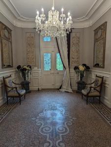 ルヴェルにあるChateau de Thuriesのシャンデリアと結婚式の祭壇のある広い客室です。