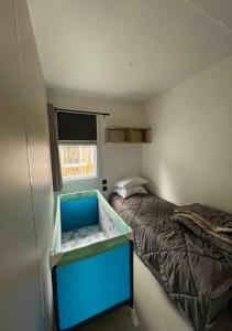 um pequeno quarto com uma cama e um berço em Familial central lac em Biscarrosse