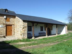 an old stone house with a porch and a door at Casa Aurora in San Esteban del Toral