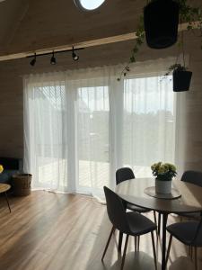 a dining room with a table and a large window at Holiday home Filipi in Ventspils