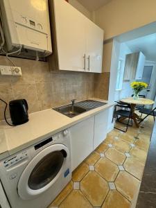 a kitchen with a washing machine and a sink at Nice Triple Room at 2 Iveragh Rd-7 in Dublin