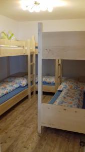 three bunk beds in a room with wooden floors at Ferienwohnug-Spitzenstein in Abfaltersbach