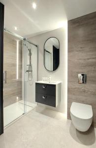 a bathroom with a toilet and a sink and a mirror at Jantar Resort Złote Piaski Jantaru by TriApart in Jantar