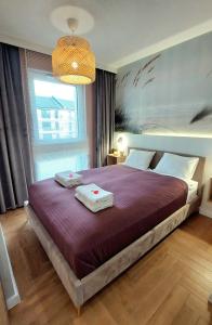 a bedroom with a large bed with two towels on it at Jantar Resort Złote Piaski Jantaru by TriApart in Jantar