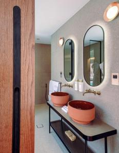 un bagno con due lavandini e due specchi di Meliá Desert Palm Member of Meliá Collection a Dubai