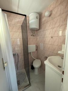 a bathroom with a shower and a toilet and a sink at Apartments Medic in Drače