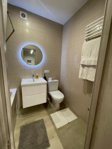La salle de bains est pourvue de toilettes, d'un lavabo et d'un miroir. dans l'établissement Квартира в парку біля озера, 10 хв до центра, 1км, à Ternopil