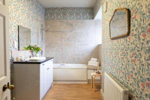 ein Badezimmer mit Badewanne, Waschbecken und Spiegel in der Unterkunft Lightfoot Cottage in Bishop Auckland + 14 Fotos