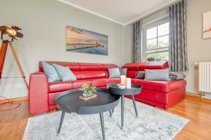 - un salon avec un canapé rouge et une table dans l'établissement Friedenstraße 17 Whg 3, à Zingst