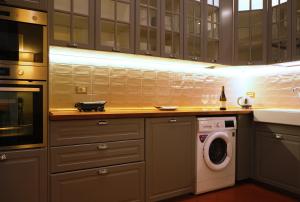 uma cozinha com uma máquina de lavar roupa e uma máquina de lavar roupa em Mamo Florence - Tintori Luxury Palace em Florença