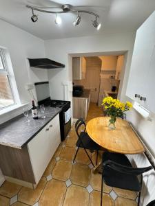 Nice Triple Room at 2 Iveragh Rd-7 في دبلن: مطبخ مع طاولة خشبية وطاولة وكراسي